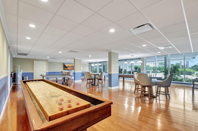 playroom featuring light wood-type flooring and a drop ceiling