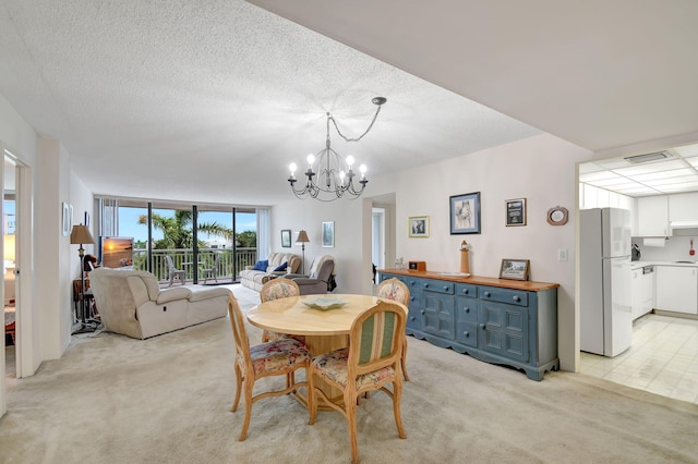 carpeted dining room with a textured ceiling and a chandelier