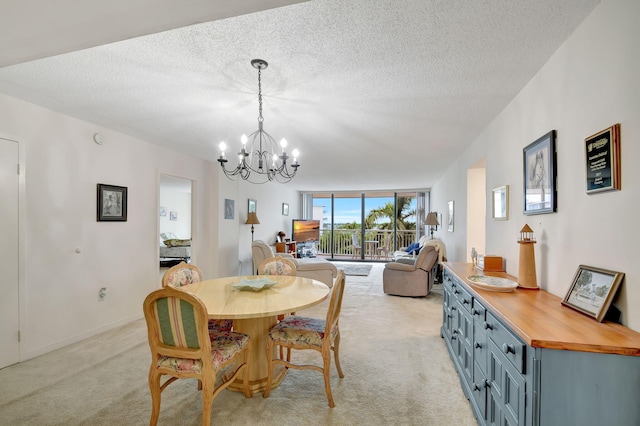 dining room featuring a notable chandelier, a textured ceiling, and light carpet