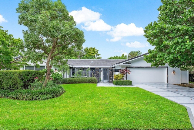 ranch-style house featuring concrete driveway, an attached garage, fence, a front lawn, and stucco siding