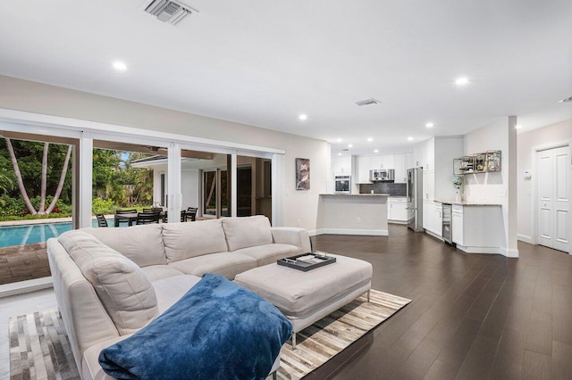 living room featuring dark wood-style floors, recessed lighting, visible vents, and baseboards