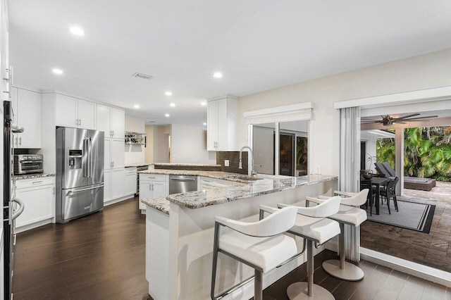 kitchen with stainless steel appliances, dark wood-style flooring, a sink, and a toaster