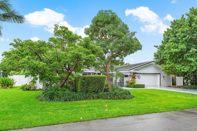 view of front of property featuring a garage and a front lawn