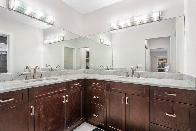 bathroom featuring a sink and double vanity