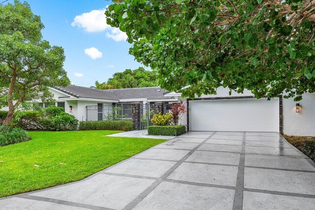 ranch-style house with a garage and a front lawn