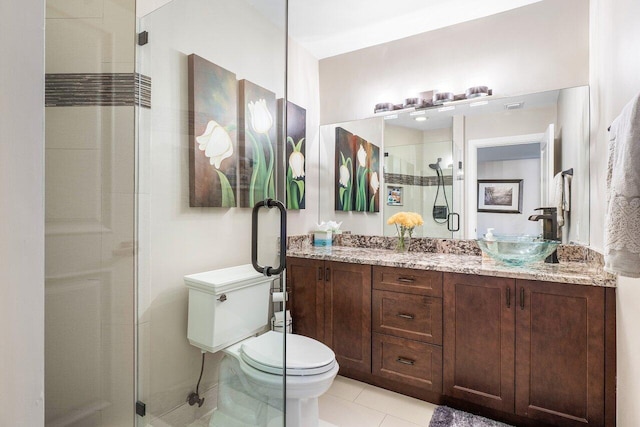 bathroom featuring vanity, a stall shower, tile patterned flooring, and toilet