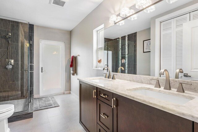 bathroom featuring tile patterned floors, an enclosed shower, vanity, and toilet