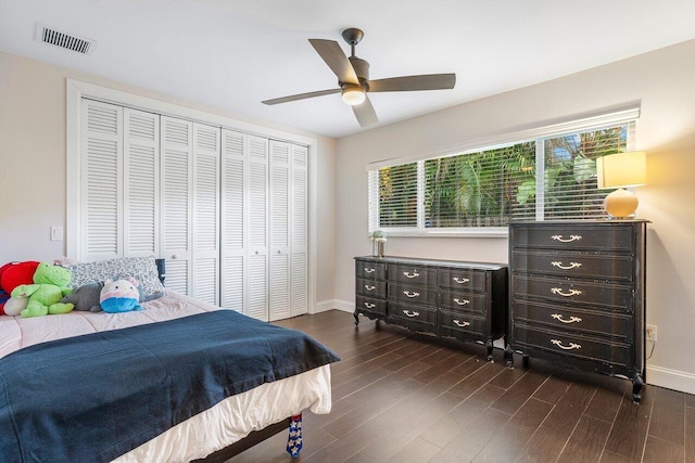 bedroom featuring dark wood finished floors, a closet, visible vents, ceiling fan, and baseboards