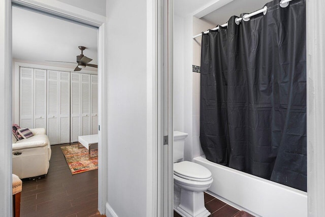 full bath featuring a ceiling fan, shower / bathtub combination with curtain, toilet, and wood finished floors