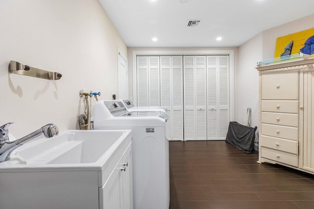 washroom with wood-type flooring, independent washer and dryer, and cabinets