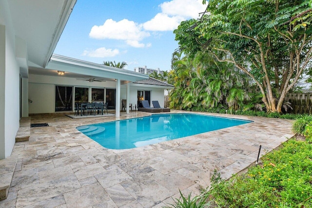 outdoor pool with outdoor dining area, a patio area, and ceiling fan