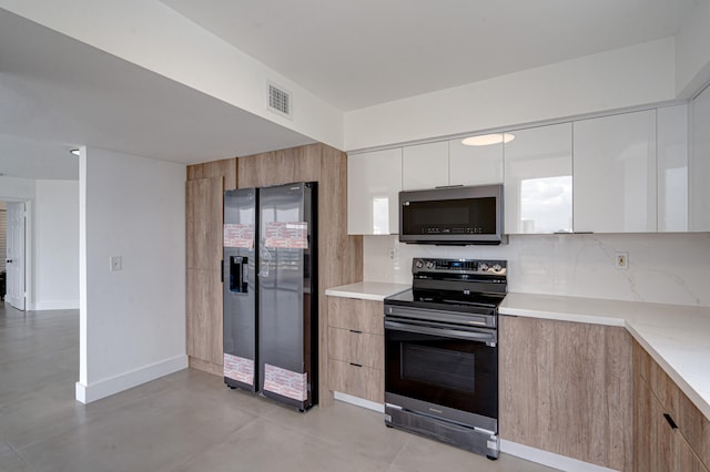 kitchen featuring appliances with stainless steel finishes, white cabinets, and backsplash