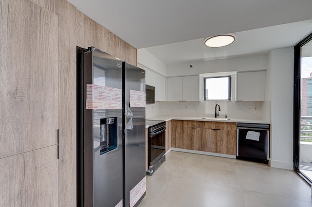 kitchen featuring decorative backsplash, white cabinets, black appliances, and sink