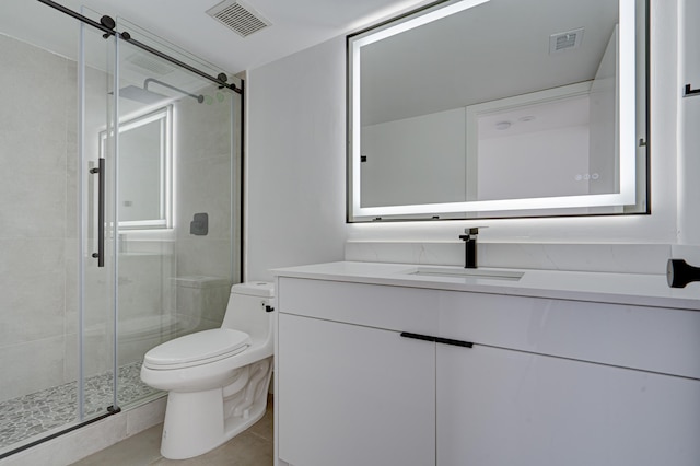 bathroom with toilet, tile patterned flooring, vanity, and a shower with door