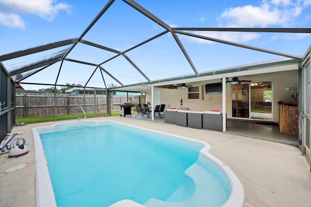 view of swimming pool featuring ceiling fan, glass enclosure, outdoor lounge area, and a patio