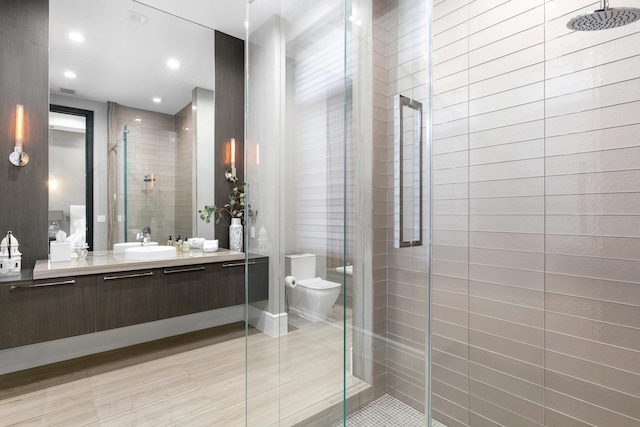 bathroom featuring tile patterned flooring, toilet, walk in shower, and vanity