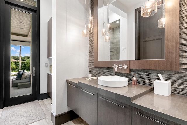 bathroom with hardwood / wood-style floors, vanity, and tasteful backsplash