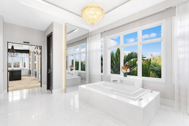 bathroom with a tub, a tray ceiling, tile patterned flooring, and a chandelier