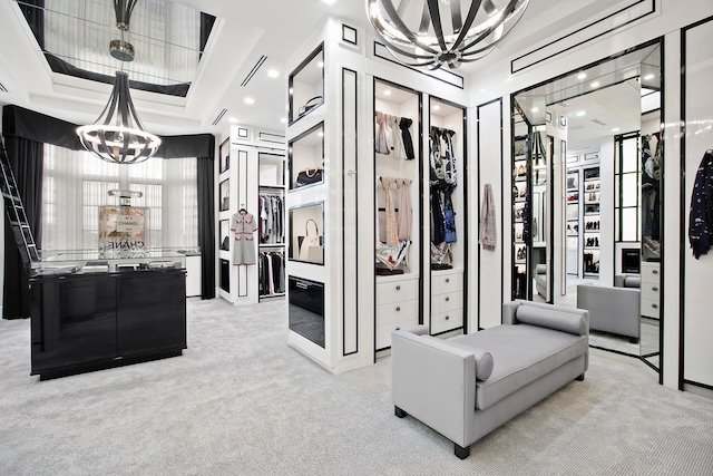 interior space with a raised ceiling, light colored carpet, and a chandelier