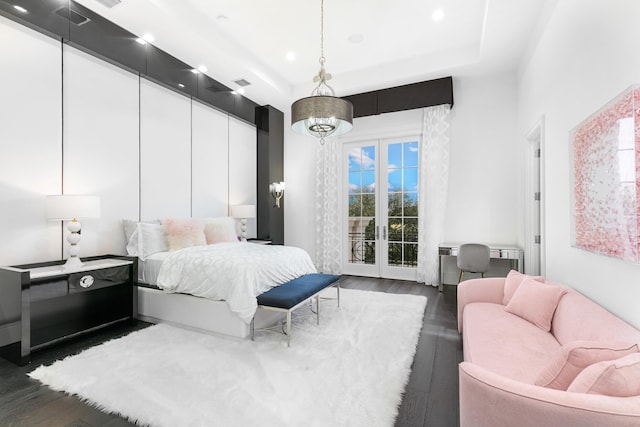 bedroom featuring access to exterior, french doors, dark hardwood / wood-style floors, and a tray ceiling