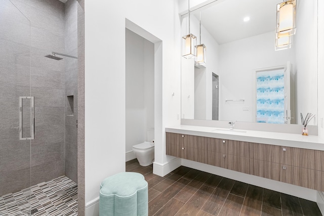 bathroom with wood-type flooring, a shower with door, toilet, and vanity