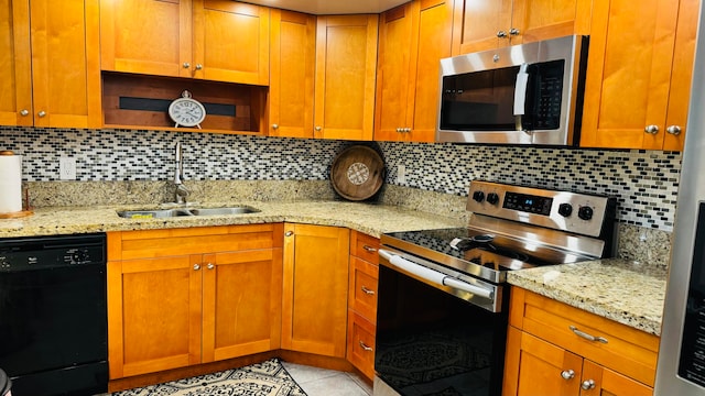 kitchen with light stone counters, light tile patterned floors, sink, backsplash, and appliances with stainless steel finishes