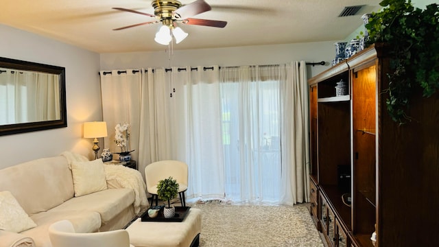 carpeted living room with ceiling fan