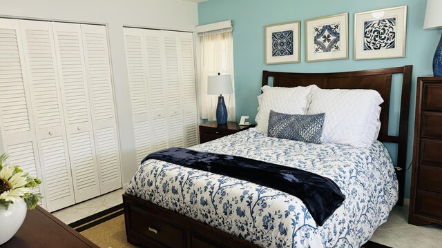 tiled bedroom featuring two closets