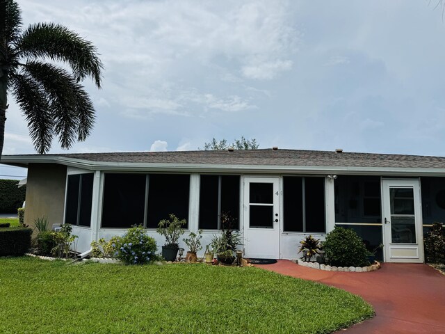 back of property featuring a sunroom and a yard