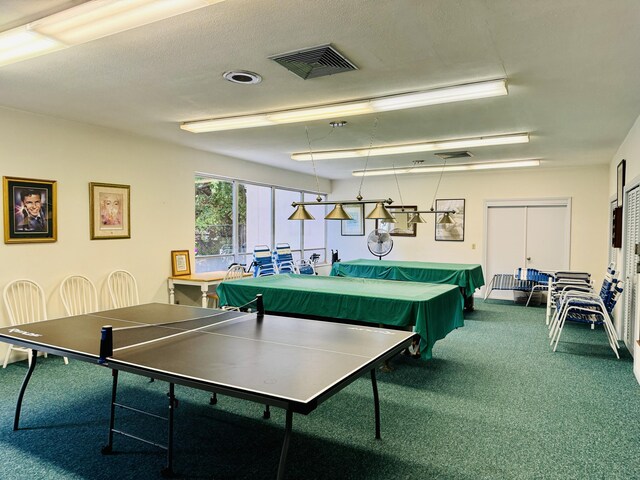 recreation room with a textured ceiling and carpet