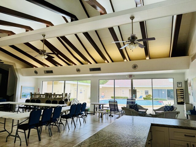 dining area featuring ceiling fan, beamed ceiling, light tile patterned floors, and high vaulted ceiling