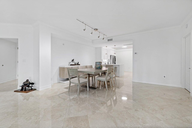 dining space featuring track lighting and crown molding