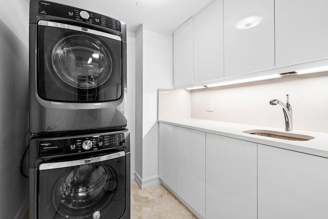 laundry room featuring stacked washer and clothes dryer, cabinets, sink, and light tile patterned flooring