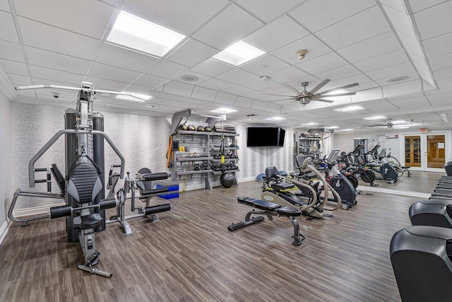 workout area featuring hardwood / wood-style flooring, a paneled ceiling, and ceiling fan