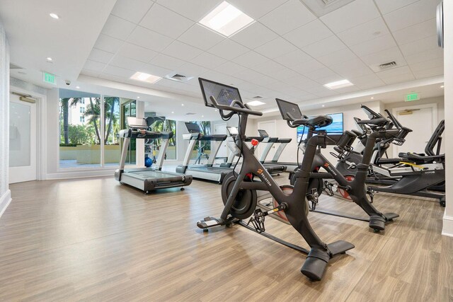 workout area with a paneled ceiling and light hardwood / wood-style floors