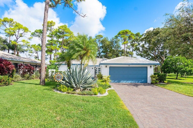 single story home with a garage and a front lawn