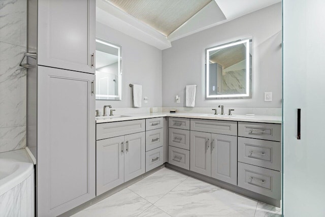 bathroom featuring vaulted ceiling, a relaxing tiled tub, and vanity