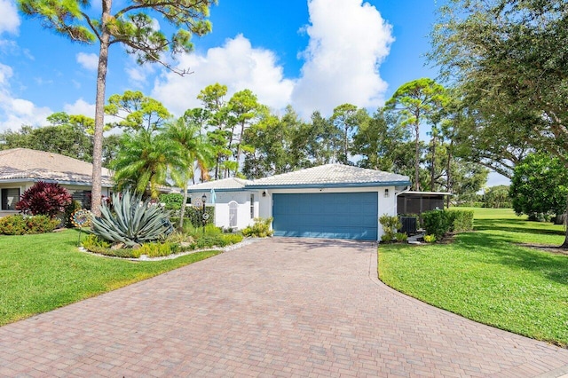 ranch-style home with central air condition unit, a garage, and a front lawn