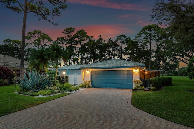 single story home featuring a garage, a yard, and central air condition unit