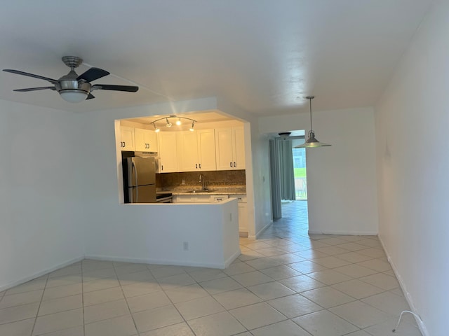 kitchen with stainless steel fridge, backsplash, hanging light fixtures, white cabinetry, and ceiling fan