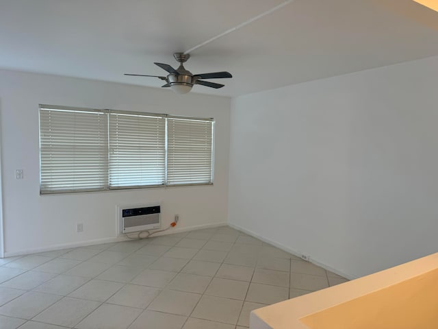 spare room featuring heating unit, light tile patterned floors, and ceiling fan