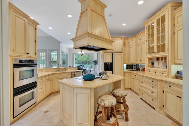 kitchen with island range hood, stainless steel appliances, light countertops, a center island, and glass insert cabinets