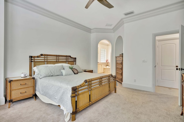 bedroom featuring baseboards, visible vents, light colored carpet, ensuite bathroom, and crown molding