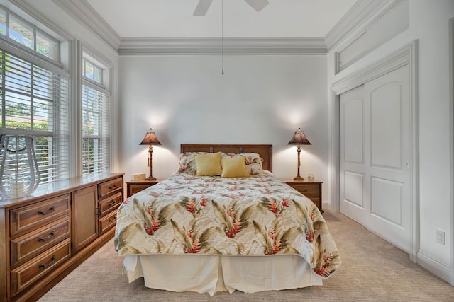 bedroom with light colored carpet, a closet, crown molding, and ceiling fan