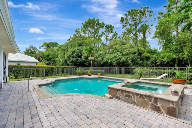 view of swimming pool featuring a patio area, a fenced backyard, and a pool with connected hot tub