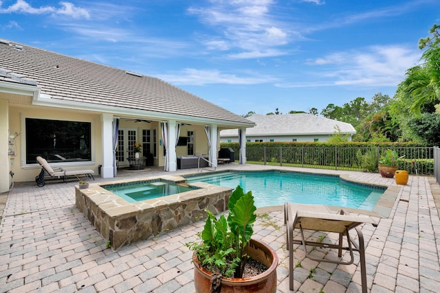 view of swimming pool with french doors, a pool with connected hot tub, a ceiling fan, a patio area, and fence