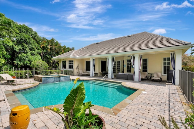 view of swimming pool featuring french doors, a patio area, fence, and a pool with connected hot tub