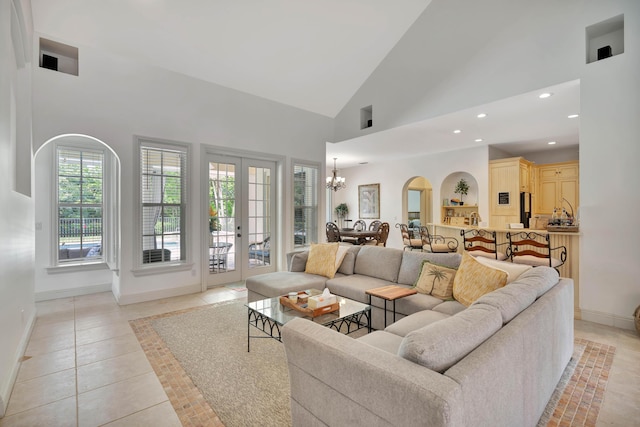 living area featuring baseboards, light tile patterned flooring, high vaulted ceiling, a notable chandelier, and recessed lighting