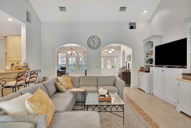 living room with high vaulted ceiling, visible vents, arched walkways, and a notable chandelier