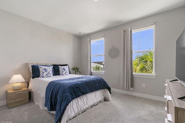 carpeted bedroom with multiple windows and baseboards